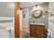 Charming bathroom featuring a rustic wooden cabinet sink, decorative mirror, and unique mosaic tile flooring at 4412 Dobys Bridge Rd, Fort Mill, SC 29707