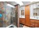 Updated bathroom features a walk-in shower with glass door and decorative tile, plus wooden vanity and cabinets at 4412 Dobys Bridge Rd, Fort Mill, SC 29707