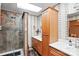 Well-lit bathroom with a walk-in shower featuring decorative tile work, paired with a matching vanity and sink area at 4412 Dobys Bridge Rd, Fort Mill, SC 29707