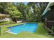 Refreshing backyard pool with easy access ladder and artificial turf, nestled in a wooded setting at 4412 Dobys Bridge Rd, Fort Mill, SC 29707