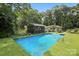 Beautiful in-ground pool with manicured artificial turf and a screened-in pool house, perfect for summer relaxation at 4412 Dobys Bridge Rd, Fort Mill, SC 29707