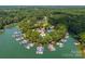 A scenic aerial view of a community marina and waterfront property surrounded by lush greenery and tranquil water at 4536 Rustling Woods Dr, Denver, NC 28037