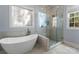 This bright bathroom features a large soaking tub and frameless glass shower with elegant fixtures at 4536 Rustling Woods Dr, Denver, NC 28037