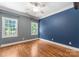 Bedroom with hardwood floors, ceiling fan, two windows, and two tone paint with gray and blue at 4536 Rustling Woods Dr, Denver, NC 28037