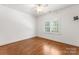 Well-lit bedroom features hardwood floors, a ceiling fan, and a large window with natural light, creating a peaceful retreat at 4536 Rustling Woods Dr, Denver, NC 28037