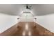Bonus room featuring light walls, unique floors, ceiling fan, trim and custom-built shelving perfect for entertaining at 4536 Rustling Woods Dr, Denver, NC 28037