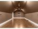 Bonus room featuring neutral paint, unique flooring, ceiling fan, mounted sconces and a tv perfect for entertaining at 4536 Rustling Woods Dr, Denver, NC 28037