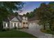 Charming home with a three-car garage, stone accents, and a basketball hoop on a well-manicured lawn at dusk at 4536 Rustling Woods Dr, Denver, NC 28037