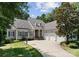 Charming home with a three-car garage, stone accents, and a basketball hoop on a well-manicured lawn at 4536 Rustling Woods Dr, Denver, NC 28037