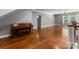 Open-concept living room featuring gleaming hardwood floors, neutral paint, and a classic piano, perfect for entertaining at 4536 Rustling Woods Dr, Denver, NC 28037