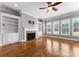 Bright living room featuring hardwood floors, built-ins, fireplace and large plantation shutters at 4536 Rustling Woods Dr, Denver, NC 28037