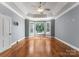 Bright main bedroom boasts hardwood floors, tray ceiling, fan, and large windows with natural light at 4536 Rustling Woods Dr, Denver, NC 28037