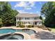 Backyard features a pool, with brick patio, hot tub, seating area, and lush greenery at 4536 Rustling Woods Dr, Denver, NC 28037