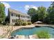 Backyard features a pool, with a brick patio, seating area, and lush greenery at 4536 Rustling Woods Dr, Denver, NC 28037