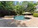 Backyard features a pool, with a brick patio, seating area, hot tub, and lush greenery at 4536 Rustling Woods Dr, Denver, NC 28037