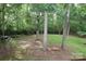Expansive backyard features mature trees and a charming swing, creating a peaceful and picturesque outdoor space at 458 Leaf Arbor Ct, Clover, SC 29710