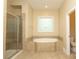 Bathroom featuring walk-in shower, soaking tub, decorative window and toilet at 458 Leaf Arbor Ct, Clover, SC 29710