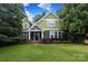 Inviting two-story green home with well-maintained landscaping and a stone-clad front porch at 458 Leaf Arbor Ct, Clover, SC 29710