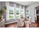 Bright dining area with hardwood floors, three windows, white curtains, and backyard access at 5042 Alston Dr, Lancaster, SC 29720