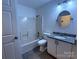 Bathroom with granite counter, tub and shower combo, and round mirror above the sink at 6007 Crosswood Ct, Charlotte, NC 28215