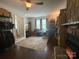 Living room with a ceiling fan, hard wood flooring, stone fireplace, and closet space in the background at 6007 Crosswood Ct, Charlotte, NC 28215