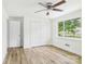 A bright bedroom featuring a ceiling fan, closet and a large window with wood-look flooring at 61 23Rd Nw St, Hickory, NC 28601