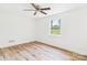 A bright bedroom featuring a ceiling fan and a large window with wood-look flooring at 61 23Rd Nw St, Hickory, NC 28601