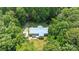 Aerial view of home with blue roof surrounded by lush green trees at 7011 S Providence Rd, Waxhaw, NC 28173