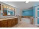 A well-lit bathroom with a double sink vanity, ceramic tile flooring, and a tiled bathtub for luxurious comfort at 7011 S Providence Rd, Waxhaw, NC 28173