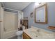 This bathroom features a toilet, a shower and a vanity with a light wood frame mirror, a towel bar and a towel ring at 7011 S Providence Rd, Waxhaw, NC 28173
