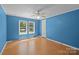 The bright bedroom has vinyl floors, a ceiling fan, and large windows that provide plenty of natural light and ventilation at 7011 S Providence Rd, Waxhaw, NC 28173