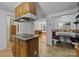 Kitchen featuring an island cooktop, wood cabinets, and an adjacent dining area with seating at 7011 S Providence Rd, Waxhaw, NC 28173