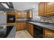 Functional kitchen with dark countertops, mosaic backsplash, wooden cabinets and an oven at 7011 S Providence Rd, Waxhaw, NC 28173