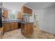 Functional kitchen featuring wood cabinets, an island cooktop, stainless steel appliances, and view into pantry at 7011 S Providence Rd, Waxhaw, NC 28173