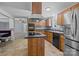 Well-equipped kitchen with wood cabinets, island cooktop, stainless steel fridge, and black appliances at 7011 S Providence Rd, Waxhaw, NC 28173