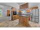 Kitchen with wooden cabinets, stainless steel appliances, island and view of the living room at 7011 S Providence Rd, Waxhaw, NC 28173