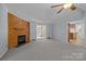 Cozy living room with a wood-paneled fireplace, neutral carpet and adjacent sunroom at 7011 S Providence Rd, Waxhaw, NC 28173