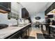 Kitchen area with black cabinets, stainless sink, marble counters, tile floor and views of dining area at 704 Willow Rd, Salisbury, NC 28147