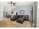 Open-concept living space with vaulted ceiling, leather sectional, wood flooring and adjacent dining area at 704 Willow Rd, Salisbury, NC 28147