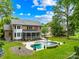 Beautiful backyard featuring a pool, patio area, screened porch, and well-maintained lawn at 7229 Olde Sycamore Dr, Mint Hill, NC 28227