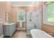 Bathroom featuring a glass-enclosed shower, soaking tub, vanity with sink, and a window at 7229 Olde Sycamore Dr, Mint Hill, NC 28227