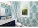 Bathroom featuring striking palm wallpaper, modern fixtures, and a sleek vanity with a bright mirror at 7229 Olde Sycamore Dr, Mint Hill, NC 28227