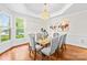 Formal dining room featuring hardwood floors, decorative lighting, and large windows at 7229 Olde Sycamore Dr, Mint Hill, NC 28227