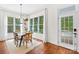 Well-lit dining room featuring large windows, dark modern chandelier, and a door that leads to the porch at 7229 Olde Sycamore Dr, Mint Hill, NC 28227