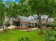 Beautiful brick home featuring lush landscaping, mature trees, and a well-maintained lawn at 7229 Olde Sycamore Dr, Mint Hill, NC 28227