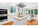 Bright kitchen with granite countertops, stainless steel appliances, and a center island cooktop at 7229 Olde Sycamore Dr, Mint Hill, NC 28227