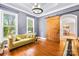 Cozy living room with hardwood floors, a decorative sliding barn door, and many bright, sunlit windows at 7229 Olde Sycamore Dr, Mint Hill, NC 28227