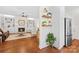 Open-concept living room with hardwood floors, fireplace, built-ins, and stainless steel refrigerator at 7229 Olde Sycamore Dr, Mint Hill, NC 28227