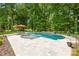 Beautiful pool with travertine surround and lush landscaping, ideal for outdoor entertaining at 7229 Olde Sycamore Dr, Mint Hill, NC 28227