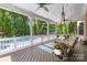 Charming covered porch with swing overlooking pool and lush greenery at 7229 Olde Sycamore Dr, Mint Hill, NC 28227